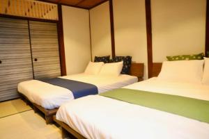 two beds in a hotel room with twothirdsessions at 動物園前駅まで徒歩5分/通天閣近く/道頓堀エリアまで電車3分/大阪グルメ旅行に最適！ in Osaka