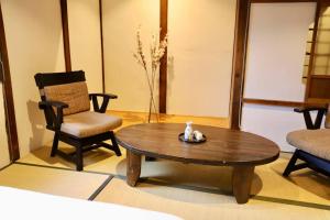 a living room with a coffee table and a chair at 動物園前駅まで徒歩5分/通天閣近く/道頓堀エリアまで電車3分/大阪グルメ旅行に最適！ in Osaka