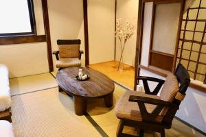 a living room with a wooden table and chairs at 動物園前駅まで徒歩5分/通天閣近く/道頓堀エリアまで電車3分/大阪グルメ旅行に最適！ in Osaka