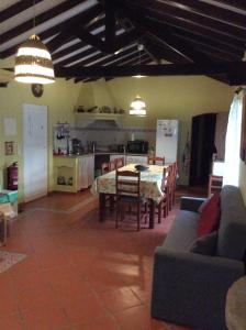 a living room with a table and a kitchen at Country House Porto Covo, Monte da Casa Velha in Santiago do Cacém