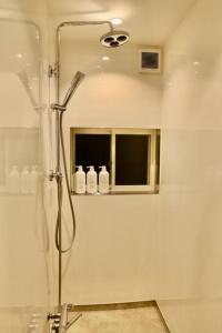 a bathroom with a shower with a window and a mirror at 動物園前駅まで徒歩5分/通天閣近く/道頓堀エリアまで電車3分/大阪グルメ旅行に最適！ in Osaka