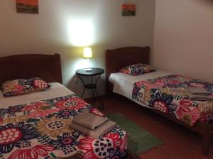 una camera con due letti e un tavolo con una lampada di Country House Porto Covo, Monte da Casa Velha a Santiago do Cacém