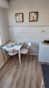 a kitchen with a white table and chairs in a room at DAMS Apartament Oświęcim in Oświęcim
