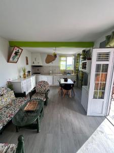 a large living room with a table and a kitchen at La maison de campagne in Morne-à-lʼEau