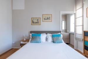 een slaapkamer met een groot wit bed met blauwe kussens bij Top Floor Apt with Rooftop Terrace near St. Peter in Rome