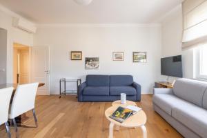 ein Wohnzimmer mit einem blauen Sofa und einem TV in der Unterkunft Top Floor Apt with Rooftop Terrace near St. Peter in Rom