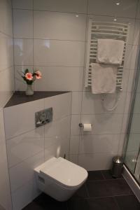 a white bathroom with a toilet and a towel at Hotel Restaurant Kromberg in Remscheid