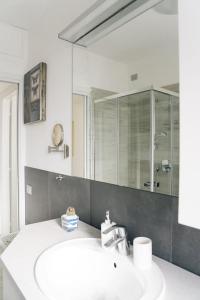 W łazience znajduje się biała umywalka i lustro. w obiekcie COZY HOUSE Relax Wi-Fi & Design w mieście Colle Brianza