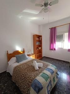 - une chambre avec un lit et un ventilateur de plafond dans l'établissement Mi Carmela, à Cenes de la Vega