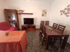 - un salon avec une table à manger et une télévision dans l'établissement Mi Carmela, à Cenes de la Vega
