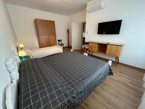 多马索CASA PAOLA Central Stay by the Lake的一间卧室，里面有一张床和一台平板电视