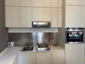 uma cozinha com armários brancos e um forno com placa de fogão em Loft 17 Arena em Verona