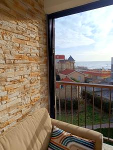 a balcony with a couch and a view of the ocean at Studio des vagues in Lacanau