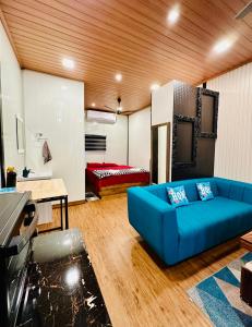una sala de estar con un sofá azul en una habitación en WHOOSH HOMES, en Kochi