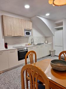 cocina con mesa, sillas y fregadero en Orisol en Vinarós