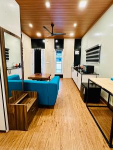 - un salon avec un canapé bleu et une table dans l'établissement WHOOSH HOMES, à Cochin