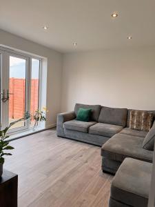 格蘭瑟姆的住宿－Modern 3 Bed home in Grantham，带沙发和大窗户的客厅