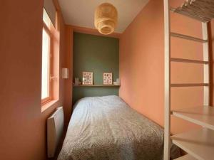 Habitación pequeña con cama y ventana en Superbe appartement avec chambre, proche plage, en Le Touquet-Paris-Plage