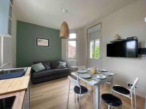 uma sala de estar com uma mesa e um sofá em Superbe appartement avec chambre, proche plage em Le Touquet-Paris-Plage