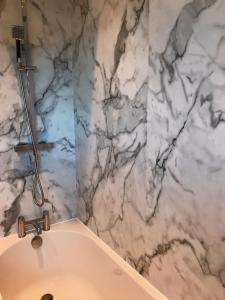baño con bañera y paredes de mármol en Modern 3 Bed home in Grantham, en Grantham