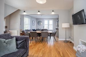 a dining room and living room with a table and chairs at Stylish and Spacious 3 Bed Apartment with Parking by Ark SA in Sheffield
