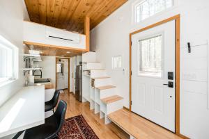 uma pequena casa com uma escada que leva a uma cozinha em Pine Creek Tiny House em Amherst