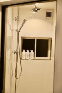 a shower in a bathroom with a mirror at 動物園前駅まで徒歩5分/通天閣近く/道頓堀エリアまで電車3分/大阪グルメ旅行に最適！ in Osaka