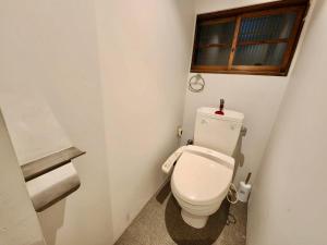 a small bathroom with a toilet and a window at 動物園前駅まで徒歩5分/通天閣近く/道頓堀エリアまで電車3分/大阪グルメ旅行に最適！ in Osaka