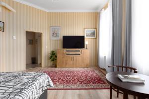 Schlafzimmer mit einem TV, einem Bett und einem Tisch in der Unterkunft Apartment ZAMECKY VRCH GETAWAY in Karlsbad