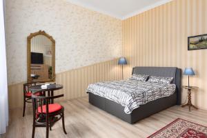 Schlafzimmer mit einem Bett, einem Tisch und einem Spiegel in der Unterkunft Apartment ZAMECKY VRCH GETAWAY in Karlsbad