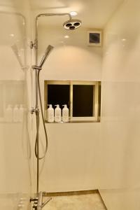a bathroom with a shower and a mirror at 動物園前駅まで徒歩5分/通天閣近く/道頓堀エリアまで電車3分/大阪グルメ旅行に最適！ in Osaka