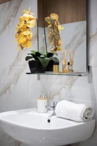 a bathroom with a sink with flowers and a shelf at Supreme Aprt Syntagma Kolonaki in Athens