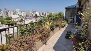 a balcony with potted plants and a view of a city at En el corazón de Palermo Soho in Buenos Aires