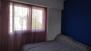 Dormitorio con ventana y cama al lado en En el corazón de Palermo Soho en Buenos Aires