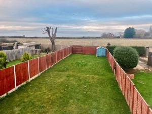 a backyard with a fence and a grass yard at Modern 3 Bed home in Grantham in Grantham