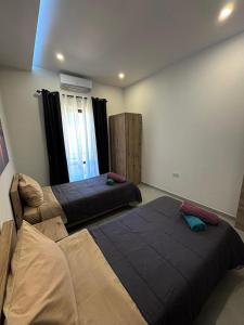 a room with two beds in a room at Diamonds country-view apt in Marsalforn