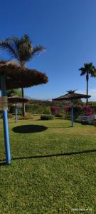 een park met palmbomen en een bord in het gras bij Aldea beach 3 in Manilva