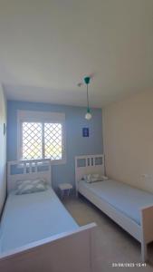 twee bedden in een kamer met twee ramen bij Aldea beach 3 in Manilva