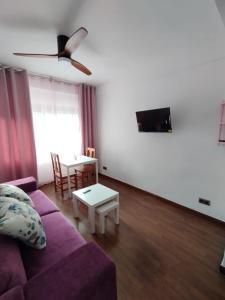 a living room with a purple couch and a table at Piso luminoso en Madrid Rio in Madrid