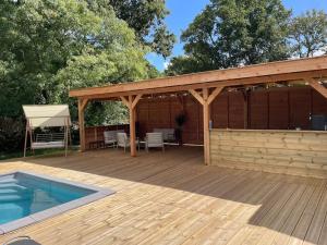 una terraza de madera con pabellón y piscina en Maison avec piscine et jacuzzi en Briere, en Saint-Lyphard