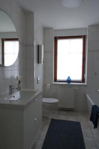 a bathroom with a sink and a tub and a toilet at Apartment Annett in Senftenberg