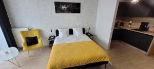 1 dormitorio con cama amarilla y silla amarilla en Hanza Tower Apartament 306, BASEN, SAUNA, JACUZZI, FITNESS, en Szczecin