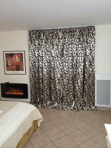 a bedroom with a black and white curtain and a fireplace at Belle Vue de St Gervais in Saint-Gervais-les-Bains