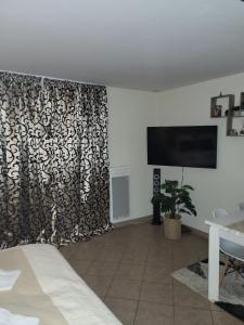 a bedroom with a black and white curtain and a tv at Belle Vue de St Gervais in Saint-Gervais-les-Bains