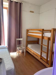 sypialnia z 2 łóżkami piętrowymi i krzesłem w obiekcie HOSTAL DANIEL w Madrycie