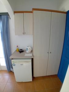 a small kitchen with a white refrigerator and cabinets at Agnantema in Irakleia