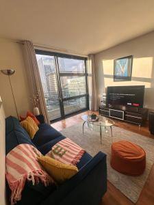 a living room with a blue couch and a television at Central London Large 1 Bed flat with Balcony in London