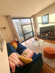 a living room with a blue couch and a large window at Central London Large 1 Bed flat with Balcony in London