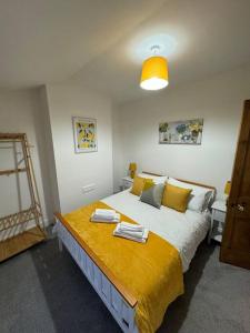 a bedroom with a large bed with towels on it at 2-bedroom house in Cheltenham town centre in Cheltenham