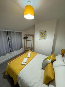 1 dormitorio con 1 cama grande y 2 toallas. en 2-bedroom house in Cheltenham town centre, en Cheltenham